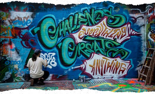 Person painting a graffiti mural